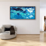 Abstract oil painting on canvas with rich impasto texture hanging in a modern living room with a beige sofa