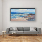 Beach painting, original oil painting on canvas hanging in a modern living room with a gray sofa