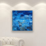 Blue Abstract oil painting on canvas with rich impasto texture hanging in a modern living room with a white sofa, viewed from a medium distance.