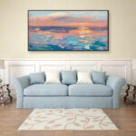 Abstract sunset painting, original oil painting on canvas hanging in a modern living room with a blue sofa