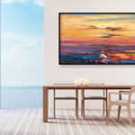 Sunset painting, original oil painting on canvas hanging in a modern living room with a table and ocean view