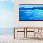 Beach painting, original oil painting on canvas hanging in a modern living room with table and ocean view