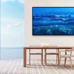 Blue ocean painting, original oil painting on canvas hanging in a modern living room with a table and ocean view